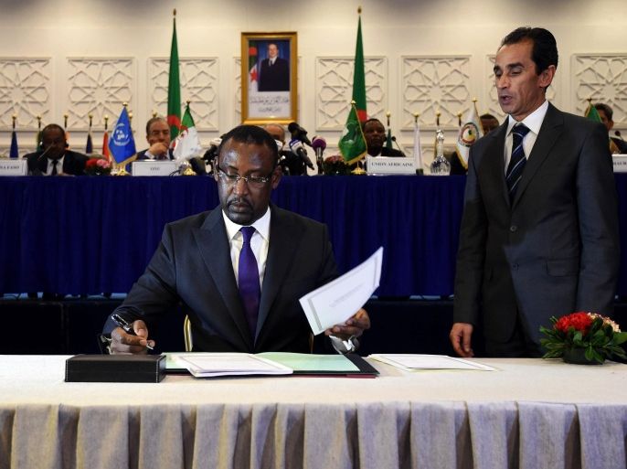 Malian Foreign Minister Abdoulaye Diop (C) signs a peace agreement as part of mediation talks between the Malian government and some northern armed groups, on March 1, 2015 in the Algerian capital Algiers. Bamako signed a peace agreement with northern militants but the main Tuareg rebel alliance asked for more time to consult its grassroots. The deal, hammered out in eight months of tough negotiations in neighbouring Algeria, provides for the transfer of a raft of powers from Bamako to the north, an area the size of Texas that the rebels refer to as 'Azawad'. AFP PHOTO / FAROUK BATICHE