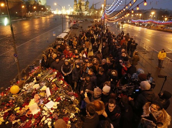 People gather at the site where Boris Nemtsov was recently murdered, with St. Basil's Cathedral and the Kremlin walls seen in the background, in central Moscow, February 28, 2015. The murder of Nemtsov drew condemnation on Saturday from leaders and politicians around the world, who paid tribute to the outspoken critic of President Vladimir Putin and Russia's role in the Ukraine crisis. REUTERS/Maxim Zmeyev (RUSSIA - Tags: POLITICS CRIME LAW CITYSCAPE)