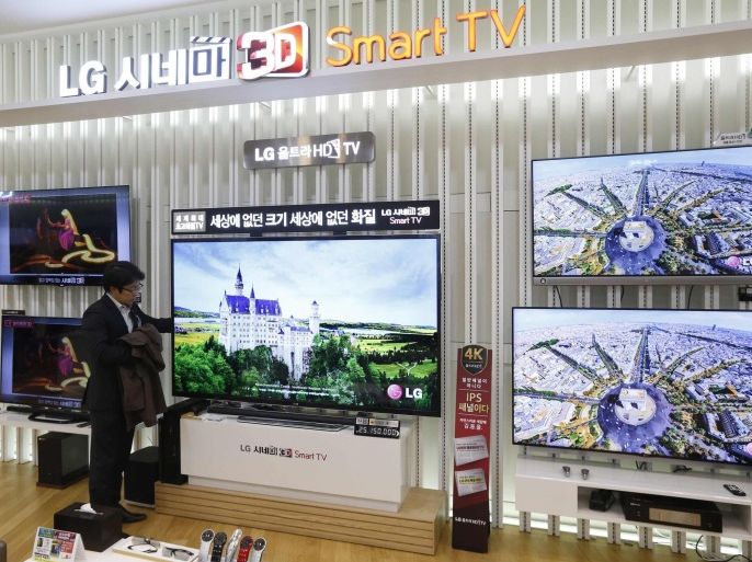 A customer looks at a LG Electronics' Ultra High Definition (UHD) TV at a store in Seoul January 23, 2014. LG Electronics Inc beat analyst estimates by doubling its fourth-quarter profit, as heavy promotional activity in the U.S.'s Black Friday shopping season lifted TV sales, offsetting a small loss at its mobile arm. Operating profit totalled 238 billion won ($220 million) in October-December, the world's second-biggest TV maker after Samsung Electronics Co Ltd said in a statement on January 27, 2014. Picture taken January 23, 2014. REUTERS/Kim Hong-Ji (SOUTH KOREA - Tags: BUSINESS SCIENCE TECHNOLOGY)