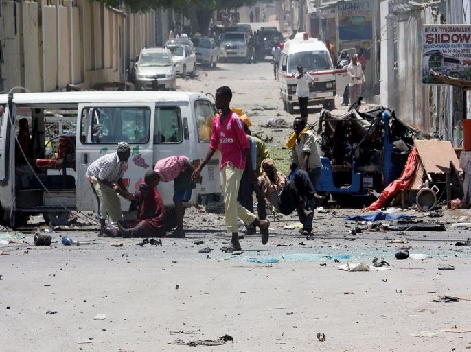 MOGADISHU, SOMALIA - APRIL 14 : Somali security forces evacuate injured and dead bombing victims from the scene of an explosion after a suicide bomber blew up his explosives-laden vehicle near the Education Ministry headquarters in Somali capital Mogadishu on April 14, 2015.