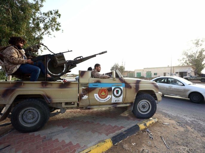 Fighters from the Fajr Libya (Libya Dawn), an alliance of Islamist-backed militias, keep watch in al-Aziziyah, located some 40 kilometres south of the Libyan capital Tripoli, on March 25, 2015. AFP PHOTO / MAHMUD TURKIA