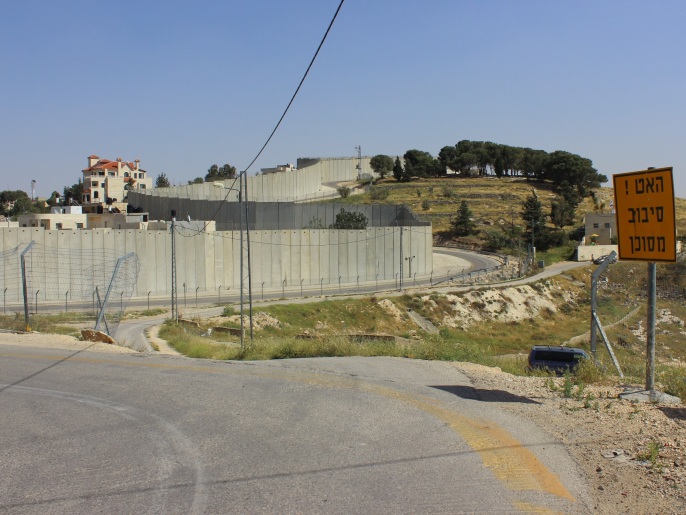 يقطع الجدار العازل بلدة أبوديس بالقدس ويجعل نصفها عرضة للمصادرة(الجزيرة)