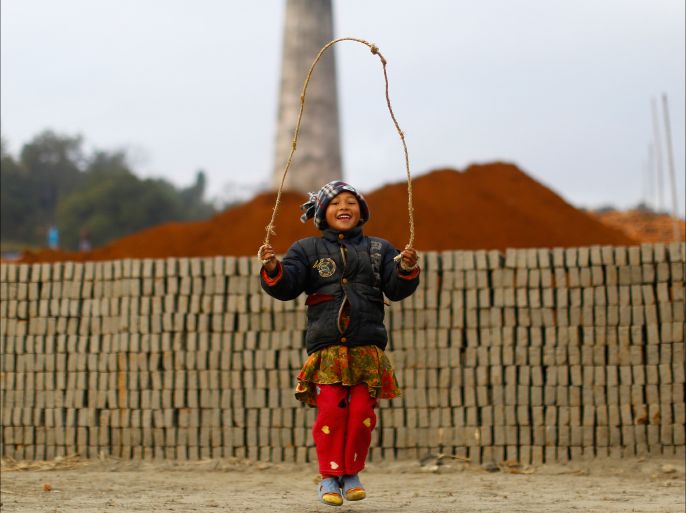 epa04547991 Nepalese girl Bina Tamang, plays with a skipping rope as her parents works at a brick factory in Lalitpur, Nepal, 06 January 2015. Indian and Nepali seasonal migrant labourers started to arrive at brick factories around the Kathmandu valley with beginning of winter season. EPA/NARENDRA SHRESTHA