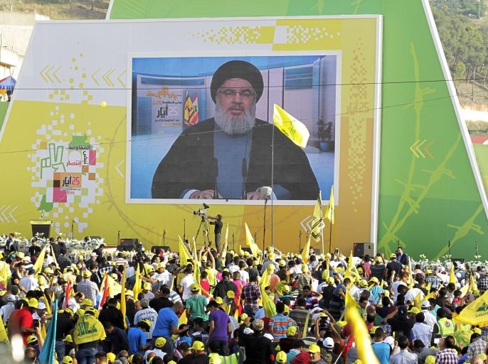 Supporters of Hezbollah wave Lebanese and Hezbollah flags as they listen to Hezbollah leader, Sayyed Hassan Nasrallah (on the screen), deliver a televised speech during celebrations in the southern town of Nabatyeh, Lebanon, 24 May 2015. During a speech delivered by the leader of Hezbollah, Sayyed Nasrallah, he likened the current threat of the group calling themsleves Islamic State (IS) to that of the Israeli invasion of Lebanon in 1982, as then as now people did not know how to deal with the changed situtation.