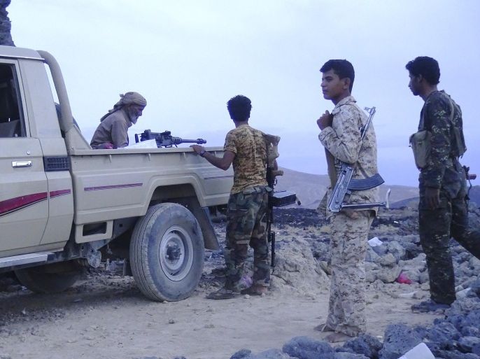Armed Yemeni fighters, loyal to Yemen's Saudi-backed President Abedrabbo Mansour Hadi, stand next to a vehicle with a machine gun during reported clashes with Shiite Huthi rebels in the area of Sirwah, in the west of Marib province, east of the capital, Sanaa, on May 24, 2015. AFP PHOTO / STR