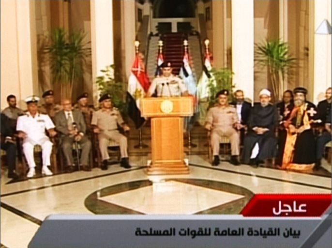 An image grab taken from Egyptian state TV shows Egyptian Defence Minister Abdelfatah al-Sissi delivering a statement as opposition leader Mohamed ElBaradei (L), the heads of the Coptic Church and Al-Azhar -- Sunni Islam's highest seat of learning and other officials sit next to him on July 3, 2013 during the unveiling of a roadmap for Egypt's political future, with state media reporting that the plan sets a tight schedule for new elections. A top aide to Egypt's President Mohamed Morsi slammed what he called a "military coup" as an army ultimatum passed and the security forces slapped a travel ban on the Islamist leader AFP PHOTO/EGYPTIAN TV == RESTRICTED TO EDITORIAL USE - MANDATORY CREDIT "AFP PHOTO / EGYPTIAN TV" - NO MARKETING NO ADVERTISING CAMPAIGNS - DISTRIBUTED AS A SERVICE TO CLIENTS ===