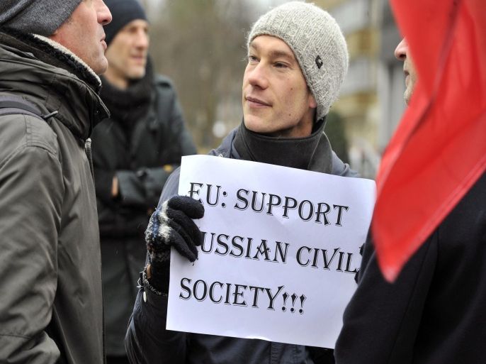 A man holds a sign as Non-Governmental Organisation (NGO) members and activists gather near the EU Headquarters in Brussels on January 27, 2014 during a protest against the Russian government's crackdown on civil society. The protest came on the eve of the EU-Russia summit, which will be attended by Russian President Vladimir Putin. AFP PHOTO/GEORGES GOBET