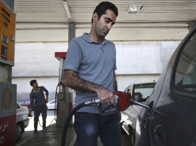 Iranians fill their cars in a gas station in central Tehran, Iran, Friday, April 25, 2014. The Iranian government on Friday cut a portion of fuel subsidies, nearly doubling some prices at the pump as part of a second round of cuts delayed since 2012. (AP Photo/Vahid Salemi)