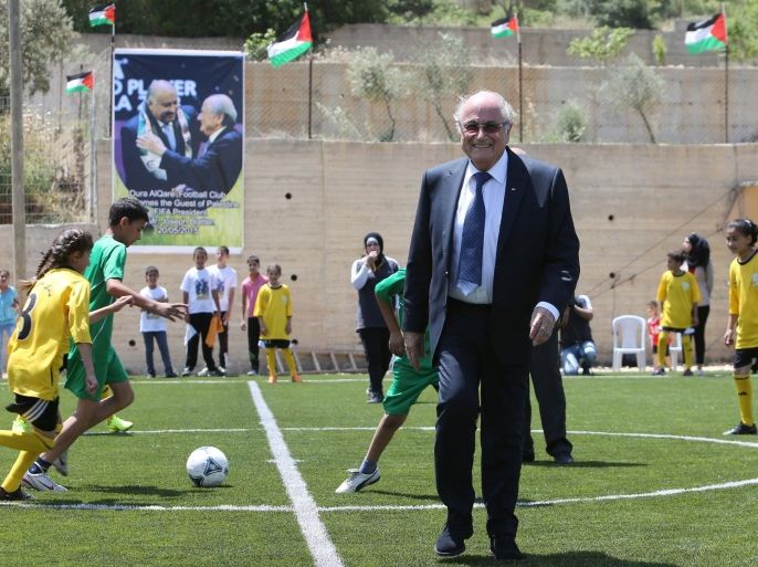 FIFA president Joseph Blatter plays football with Palestinian children during his visit to the village of Dura al-Qaraa, near the West Bank city of Ramallah, on May 20, 2015. Blatter hopes to head off a Palestinian call for a vote to expel Israel from football's governing body but that Israel must make a concession. AFP PHOTO / ABBAS MOMANI