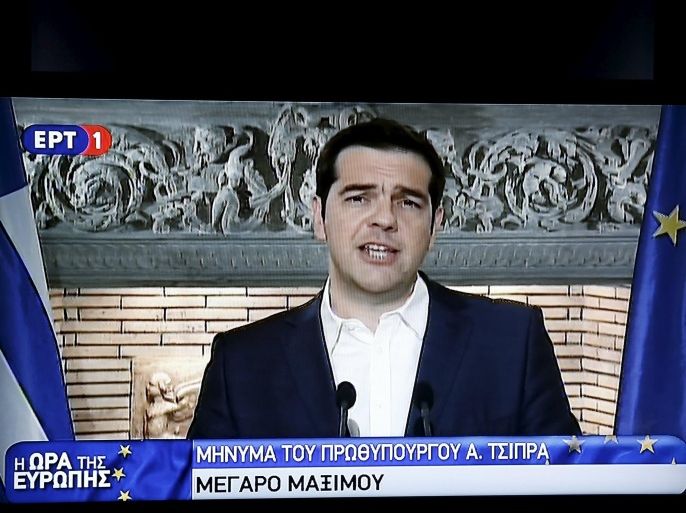 Greek Prime Minister Alexis Tsipras is seen on a television monitor whille addressing the nation early June 27, 2015. Greece will hold a referendum on July 5 to decide whether the country should accept or reject a bailout agreement offered by creditors, Tsipras said in a late-night address to the nation. REUTERS/Pool