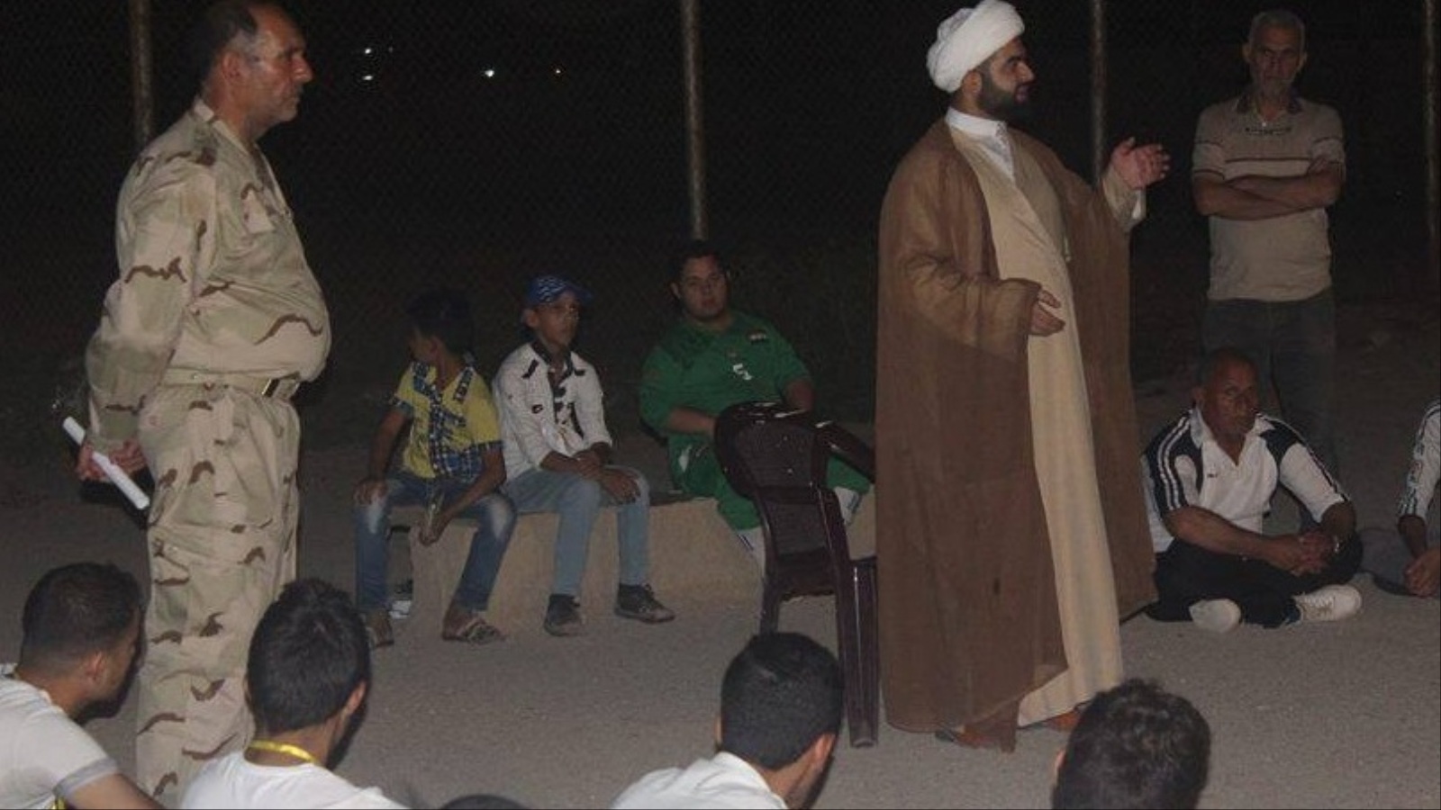 ‪رجل دين شيعي يلقي محاضرات عقائدية على الأطفال الذين يتدربون على القتال بواسطة الحشد الشعبي‬ (الجزيرة نت)