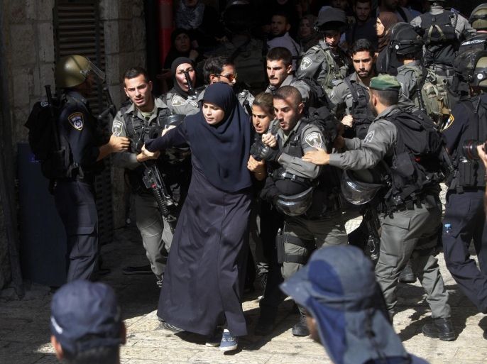 Israeli border police officers scuffle with Palestinian women in the Old City of Jerusalem on Sunday, July 26, 2015. Israeli police said they entered the al-Aqsa Mosque, a holy Jerusalem site, to prevent Arab youths from attacking visiting Jews marking a biblical holiday. (AP Photo/Mahmoud Illean)