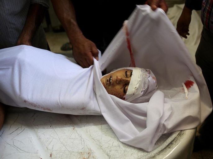 Palestinians prepare the body of a ten-year old child during his funeral in Khanyounis, in the southern Gaza Strip, 16 July 2014. Three members of a family were killed and four others injured when their car was destroyed in an airstrike. Israel stepped up its attacks on 16 July by bombing the homes of Hamas leaders after the Islamist movement rejected a truce proposal and instead launched dozens more rockets into Israel.