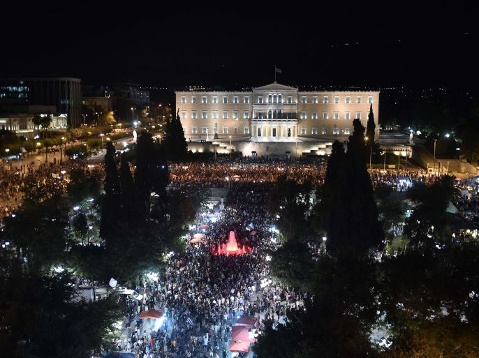 ARI068 - Athens, -, GREECE : People gather in front of the Greek Parliament in Athens on July 5, 2015, after early results showed those who rejected further austerity measures in a crucial bailout referendum were poised to win. Over 61 percent of Greek voters on July 5 rejected fresh austerity demands by the country's EU-IMF creditors in a historic referendum, official results from 50 percent of polling stations showed. AFP PHOTO / ARIS MESSINIS