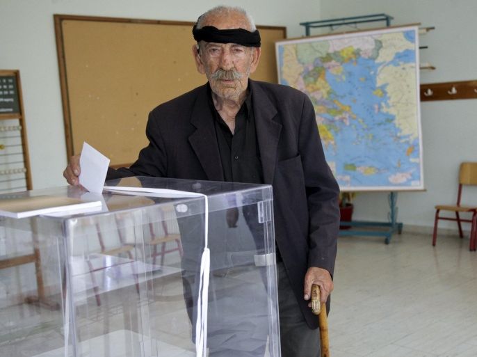 A man wearing a traditional headscarf casts his ballot at a polling station at the village of Anogeia in the island of Crete, Greece July 5, 2015. Greeks voted on Sunday whether to accept or reject the tough terms of an aid offer to stave off financial collapse, in a referendum that may determine their future in Europe’s common currency. REUTERS/Stefanos Rapines