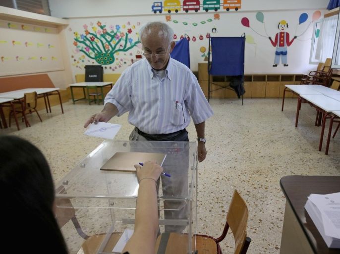 ATHENS, GREECE - JULY 05: People place their referendum votes in the ballot box at a school in the suburbs of Athens on July 5, 2015 in Athens, Greece. The people of Greece are going to the polls to decide if the country should accept the terms and conditions of a bailout with its creditors. Greek Prime Minister Alexis Tsipras is urging people to vote 'a proud no' to European creditors' proposals, and 'live with dignity in Europe'. 'Yes' campaigners believe that a no vote would mean financial ruin for Greece and the loss of the Euro currency.