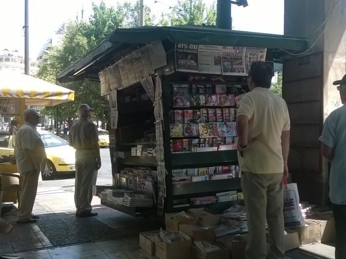 مواطنون يونانيون يقرؤون عناوين الصحف اليونانية بعد يوم واحد من الاستفتاء