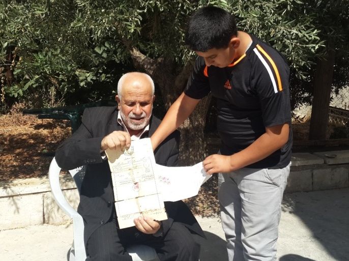رام الله فلسطين تموز 2015 الحاج عبد الرحمن قاسم يحمل وثيقة إثبات ملكية أرضه داخل مستعمرة بيت إيل