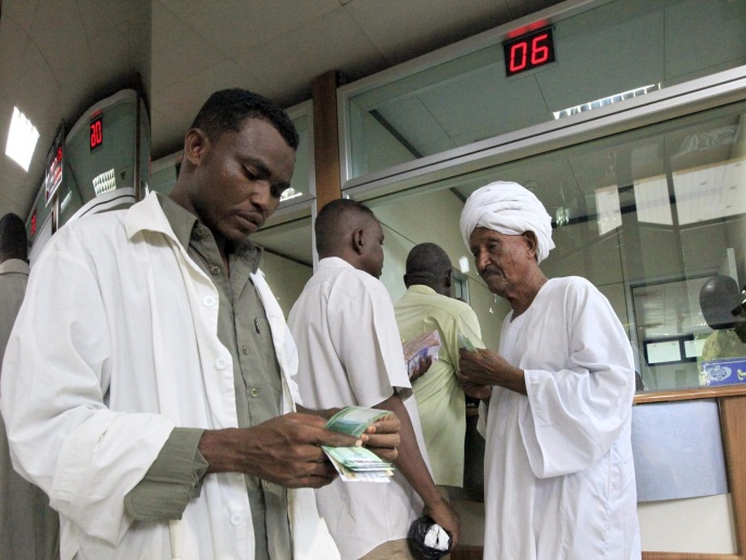 People count after receiving the new Sudanese currency at a branch of the central bank of Sudan in Khartoum July 24, 2011. Sudan will start circulating its new currency on Sunday, the central bank said, days after South Sudan started rolling out a currency of its own.
