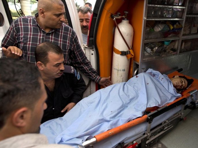 Palestinians move the body of Mohammed Amsha, 25, who was shot and killed by an Israeli policeman, from an ambulance to a hospital in the West Bank city of Nablus, Monday, Aug. 17, 2015. Israeli authorities say Amsha was shot and killed after he stabbed a guard at a West Bank checkpoint, slightly wounding him. Police spokeswoman Luba Samri says the man approached border police officers manning a checkpoint on Monday and told them he felt unwell. (AP Photo/Majdi Mohammed)