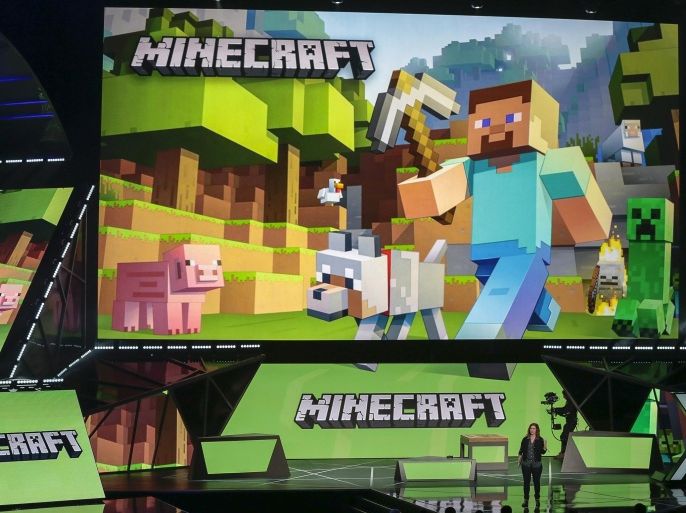 Lydia Winters, at podium, shows off Microsoft's "Minecraft" built specifically for HoloLens during a live demo at the Xbox E3 2015 briefing ahead of the Electronic Entertainment Expo at the University of Southern California's Galen Center on Monday, June 15, 2015 in Los Angeles. Microsoft is promoting the next installment in its popular sci-fi franchise, "Halo 5: Guardians," at the Electronic Entertainment Expo. (AP Photo/Damian Dovarganes)
