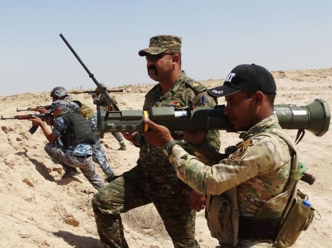 In this Thursday, July, 23, 2015 photo, Iraqi Army soldiers with new U.S.-made weapons take combat positions at the front line in an eastern suburb of Ramadi, backed by Shiite and Sunni pro-government fighters and U.S.-led coalition airstrikes against Islamic State group positions in Anbar province, Iraq. For the first time, Iraqi troops trained by the U.S.-led coalition have been added to the assault force Iraq is using to retake the city of Ramadi, a U.S. military official said Thursday. (AP Photo)