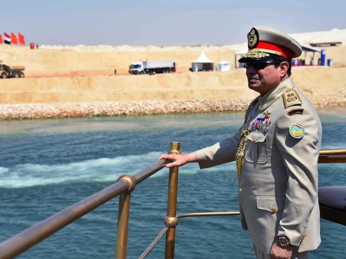 A handout picture provided by the Office of the Egyptian Presidency shows Egyptian President, Abdel Fattah al-Sisi, standing on a boat in full military uniform, as he travels down the new addition to the Suez Canal, Egypt, 06 August 2015. According to reports the the latest addition under various Egyptian regimes over the years to the canal comes in at 72 kilometer (44 mile), completed in under a year at an estimated cost of 8.5 billion US dollars, and was opened to shipping 06 August, cutting journey times from an estimated 18-14 hours to 11 hours, making it the fastest shipping lane of its kind worldwide. According to the Egyptian Government the additional chanel will double revenue, though their figures have been widely disputed by international economists. EPA/OFFICE OF THE EGYPTIAN PRESIDENT / HANDOUT