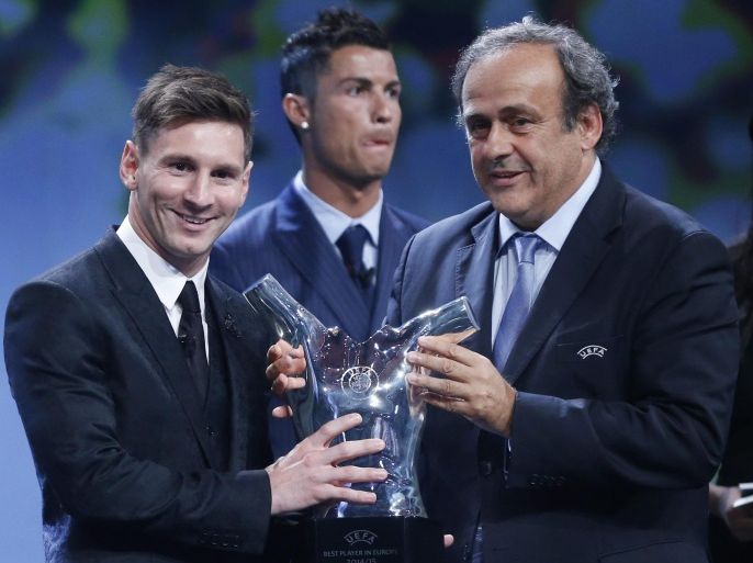 FC Barcelona's Lionel Messi (L) receives from UEFA president Michel Platini (R) his UEFA best player in Europe for 2014-2015 Award during the draw ceremony for the UEFA Champions League group stage at Grimaldi Forum in in Monte Carlo, Monaco, 27 August 2015.