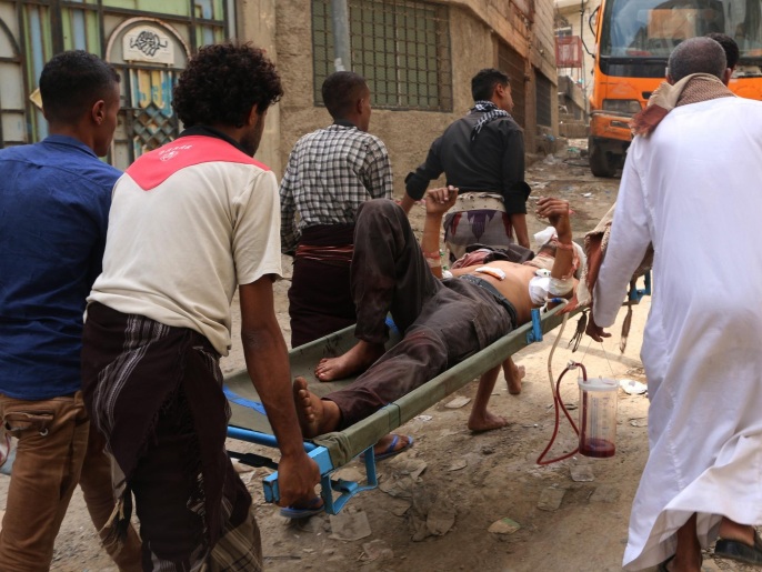 ‪مدنيون من تعز يحملون أحد الجرحى  جراء قصف للحوثيين على أحد أحياء المينة‬  (رويترز)