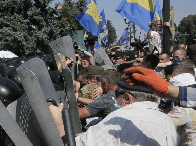Ukrainian protesters clash with police after vote to give greater powers to the east in front of the Parliament in Kiev, Ukraine, Monday, Aug. 31, 2015. The Ukrainian parliament has given preliminary approval to a controversial constitutional amendment that would provide greater powers to separatist regions in the east. (AP Photo/Efrem Lukatsky)