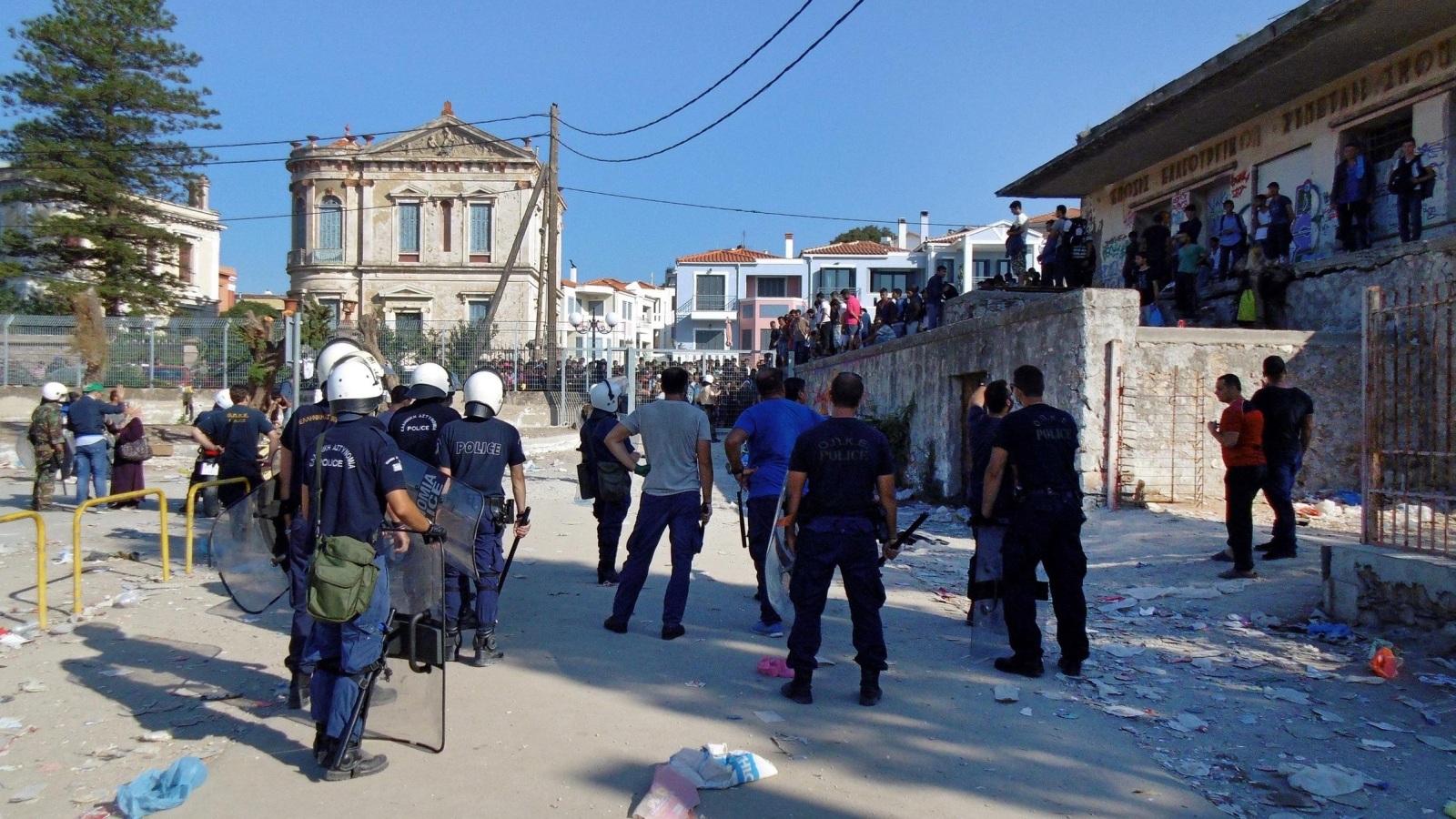 ‪الشرطة اليونانية في مواجهة لاجئين معظمهم أفغان في ميناء جزيرة ليسبوس ببحر إيجه‬ (الأوروبية)