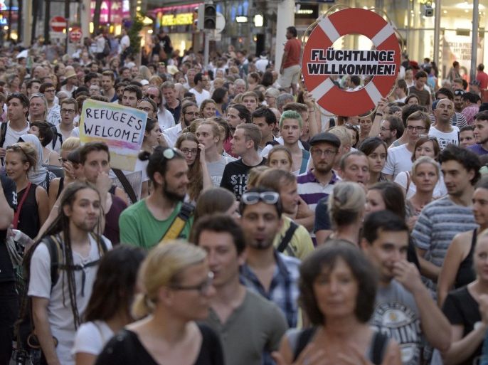 Many thousands of protesters including Austrian human right institutions, demonstrate through the streets of Vienna, Austria, on Monday, Aug. 31, 2015, after 71 migrants recently suffocated to death inside a lorry on the highway A4 near Parndorf. Heading on the banner: "Refugees welcome". (AP Photo/Hans Punz)