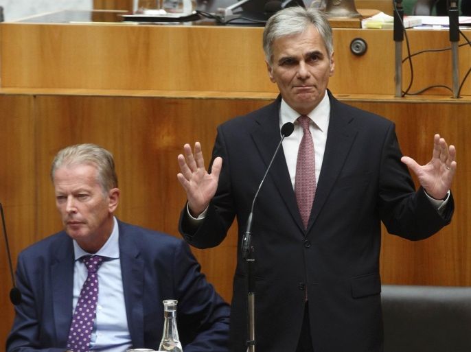 Austrian Chancellor Werner Faymann (R) talks next to Vice Chancellor Reinhold Mitterlehner during an extraordinary session of the parliament on migration policy in Vienna, Austria, September 1, 2015. REUTERS/Heinz-Peter Bader