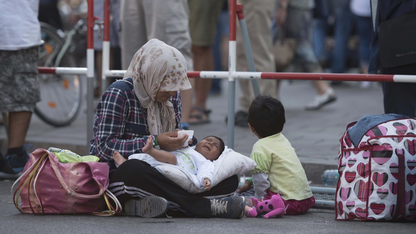 ‪أسوشيتد برس‬ لاجئة مع أطفالها خارج محطة القطار الرئيسية بمدينة ميونخ الألمانية