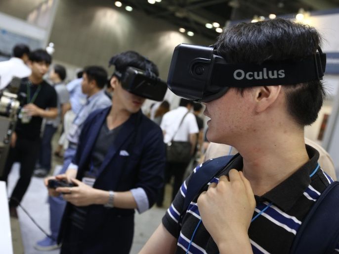 Attendees wearing the Oculus VR Inc. Rift headset play video games at the RoboUniverse Conference & Expo in Goyang, South Korea, on Wednesday, June 24, 2015. The robotics conference and exposition runs through June 26.