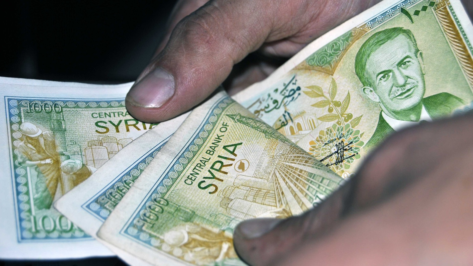 كثير من السوريين يعتمدون على تجار الشنطة لاستلام وتبديل العملات خشية التضييق الأمني(الجزيرة)