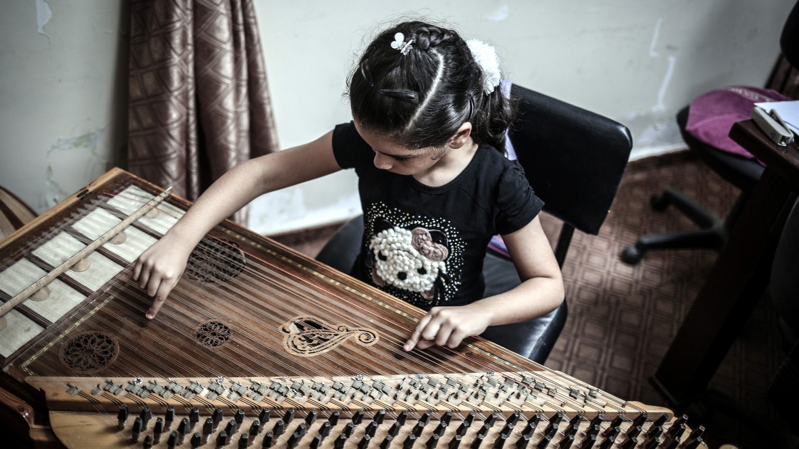 ‪طفلة فلسطينية تتدرب على العزف على القانون‬ (الأناضول)