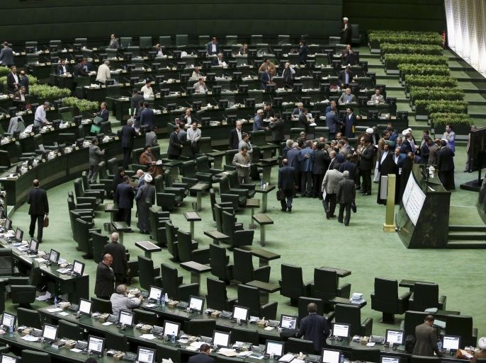 Some lawmakers get up from their seats to talks to head of Iran's Atomic Energy Organization Ali Akbar Salehi after his speech in an open session to discuss a bill on Iran's nuclear deal with world powers, at the parliament in Tehran, Iran, Sunday, Oct. 11, 2015. Iran's official IRNA news agency reported Sunday the country's parliament has approved an outline of a bill that allows the government to implement a historic nuclear deal reached between Iran and world powers. (AP Photo/Ebrahim Noroozi)