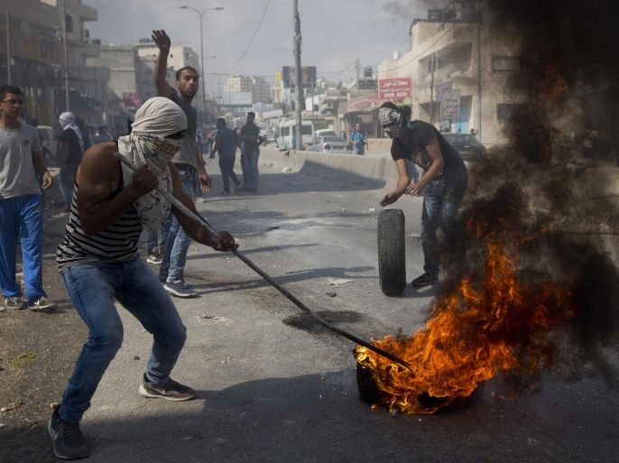 Palestinians burn tires during clashes with Israeli troops at Qalandia checkpoint between Jerusalem and the West Bank city of Ramallah, Tuesday, Oct. 6, 2015. A new generation of angry, disillusioned Palestinians is driving the current wave of clashes with Israeli forces: They are too young to remember the hardships of life during Israel's clampdown on the last major uprising, and after years of nationalist Israeli governments many have lost faith in statehood through negotiations and believe Israel only understands force. (AP Photo/Majdi Mohammed)