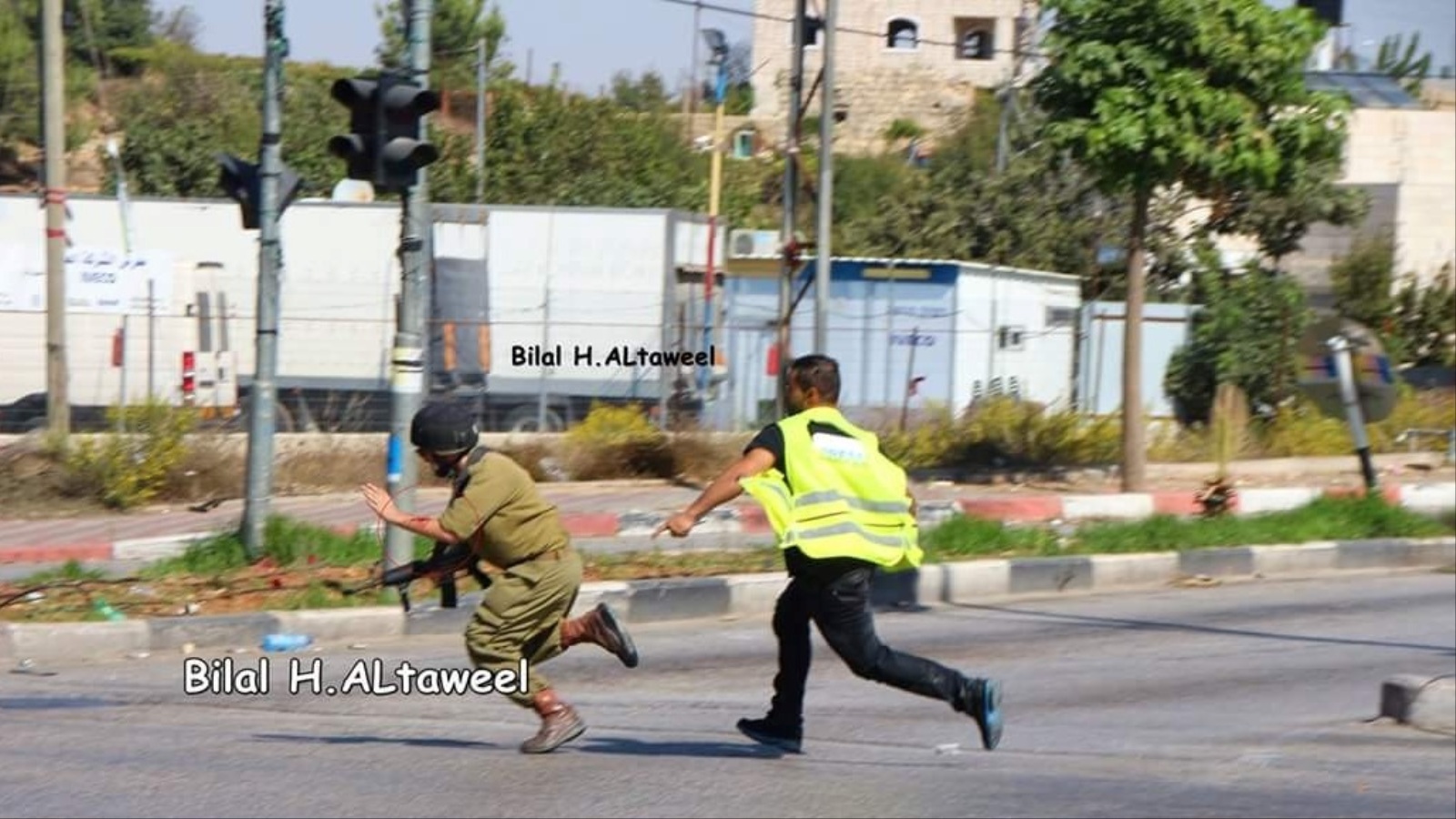 ‪صورة التقطها المصور بلال الطويل لمطاردة شاب فلسطيني جنديا إسرائيليا بمدخل مدينة الخليل‬  (الجزيرة نت)