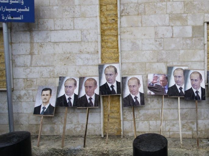 FILE - In this Sunday, March 4, 2013 file photo, photos of Syrian President Bashar Assad and Russian President Vladimir Putin are propped against a wall during a pro-Syrian government protest in front of the Russian Embassy in Damascus, Syria. Putin is winning plaudits from many Syrians and Iraqis, who see Russia's military intervention in Syria as a turning point after more than a year of largely ineffectual efforts by the U.S.–led coalition battling the Islamic State group. (AP Photo/Muzaffar Salman, File)