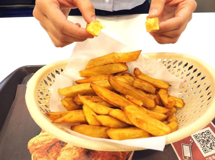 A clerk displays French fries made with sweet potatoes at a Kentucky Fried Chicken (KFC) outlet in Taipei, Taiwan, 09 January 2015. All the 124 KFC outlets in Taiwan switched from potato fries to fries mdae with Taiwan-grown sweet potatos on 08 January as imports are affected by dock workers' strike on US West Coast. For the same reason, McDonald's outlets in Taiwan are giving customers South Korean-made ketchup instead of US-made ketchup.
