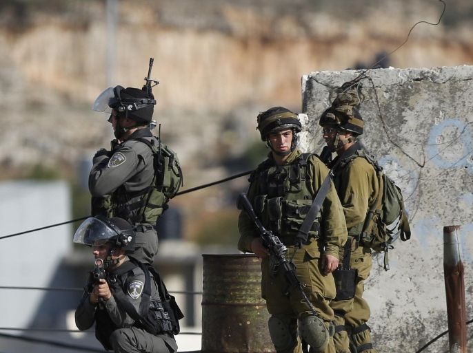 Israeli security troops take positions at the scene of a stabbing attempt, in the Beit Einun junction east of the West Bank city of Hebron, Sunday, Nov 1, 2015. The Israeli military said soldiers shot a Palestinian who had tried to stab them on Sunday in the West Bank city of Hebron, in the latest violence of a bloody six-week spell. The military said the shooting took place during a violent riot and that no Israelis were harmed. (AP Photo/Nasser Shiyoukhi)