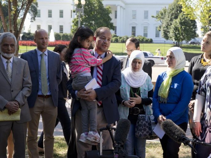 Dr. Zaher Sahloul, with the Syrian American Medical Society and American Relief Coalition for Syria, holds Shayma Alaly, 4, a refugee from Syria who has been living in Chicago since earlier this year, speaks to media standing with Syrian refugees and members of interfaith and human rights groups in Lafayette Square across from the White House in Washington, Wednesday, Sept. 16, 2015, to call on the Obama Administration to do more to address the ongoing crisis in Syria. The women at right are also refugees from Syria living in Chicago. Standing left in tan suit is Sayyid Syeed, National Director of the Islamic Society of North America. (AP Photo/Carolyn Kaster)