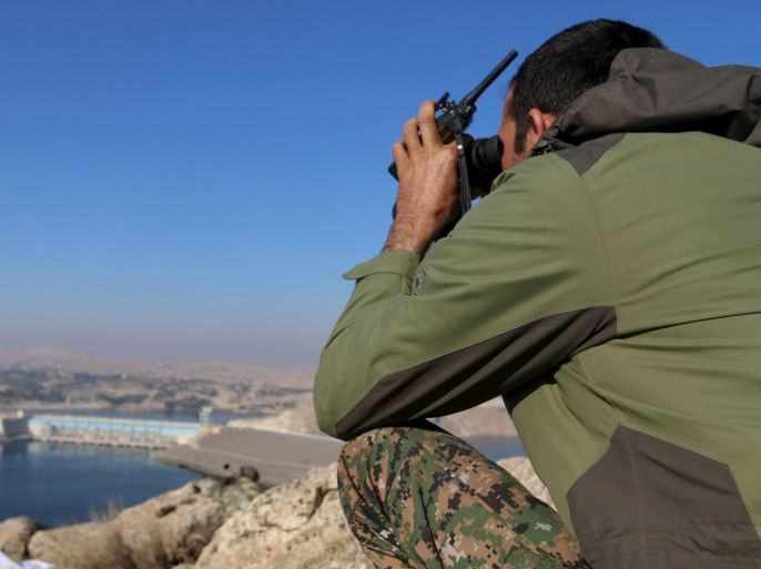 A fighter from the Democratic Forces of Syria takes an overwatch position at the top of Mount Annan overlooking the Tishrin dam, after they captured it on Saturday from Islamic State militants, south of Kobani, Syria December 27, 2015. A U.S.-backed alliance of Syrian Kurds and Arab rebel groups, supported by U.S. coalition planes, captured a dam on Saturday from Islamic State, cutting one of its main supply routes across the Euphrates, an alliance spokesman said. REUTERS/Rodi Said TPX IMAGES OF THE DAY