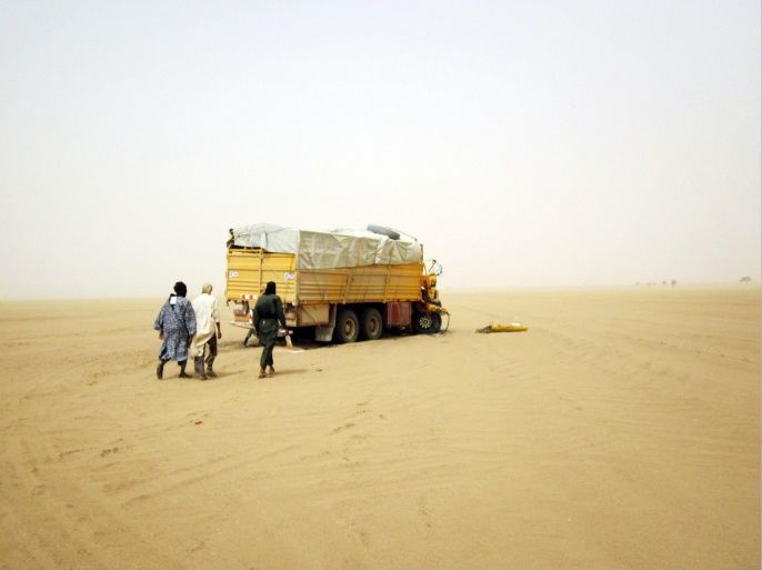 Militiaman from the Ansar Dine Islamic group approach a vehicle that had been involved in an accident in the desert of northeastern Mali, June 15, 2012. The U.N. Security Council on Monday declared its readiness to consider backing West African military intervention in Mali, where rebels and Islamist militants have seized control of much of the country, but said it needed more details on the plan. Picture taken June 15, 2012. REUTERS/Adama Diarra (MALI - Tags: POLITICS CIVIL UNREST CONFLICT RELIGION)