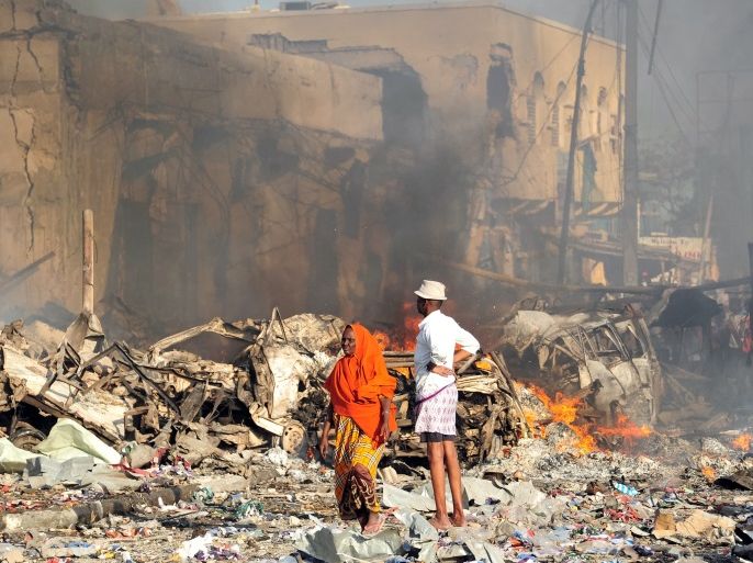 TOPSHOT - A man and woman look at the damages on the site of the explosion of a truck bomb in the centre of Mogadishu, on October 14, 2017.A truck bomb exploded outside a hotel at a busy junction in Somalia's capital Mogadishu on October 14, 2017 causing widespread devastation that left at least 20 dead, with the toll likely to rise. / AFP PHOTO / Mohamed ABDIWAHAB (Photo credit should read MOHAMED ABDIWAHAB/AFP/Getty Images)