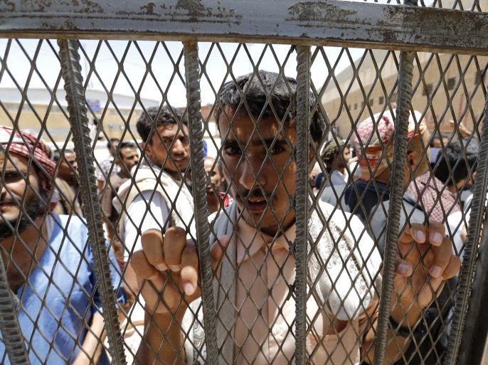 An inmate looks from behind the gate at the central prison in Sanaa May 26, 2014. REUTERS/Khaled Abdullah (YEMEN - Tags: POLITICS CRIME LAW)