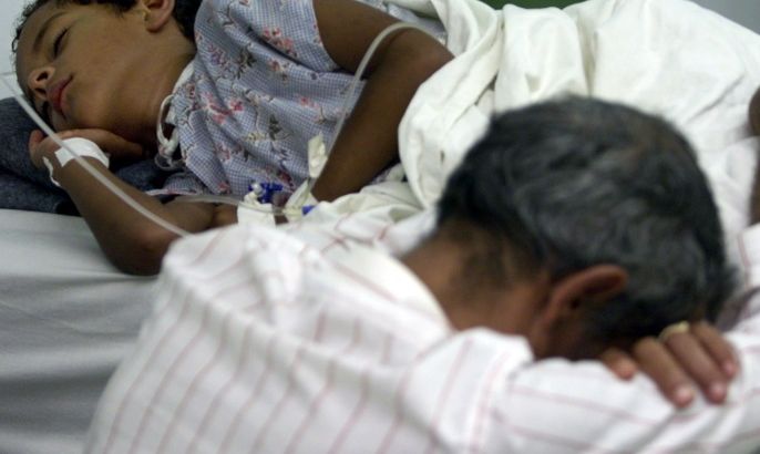 TEGUCIGALPA, HONDURAS - JULY 23: A man rests on the bed of his son, confirmed to have Hemorrhagic Dengue, after a long, sleepless night at the Hospital Escuela July 23, 2002 in Tegucigalpa, Honduras. An increase in cases of Hemorrhagic Dengue, a potentially fatal desease spread by mosquitos, has forced hospitals to stay open 24 hours a day to treat the surge in patients. The Honduran government has declared a state of emergency to combat the disease and has confirmed 11 deaths and 317 cases, as well as over 6,000 case of Classic Dengue, a non-leathal strain of the disease. (Photo by Max Trujillo/Getty Images)