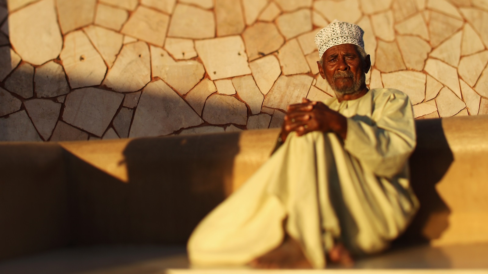 رجل يجلس في أحد المواقع الأثرية بمسقط (غيتي)